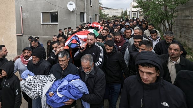 Family members and friends take part in the funeral of four members of a Palestinian family in Tamoun, West Bank