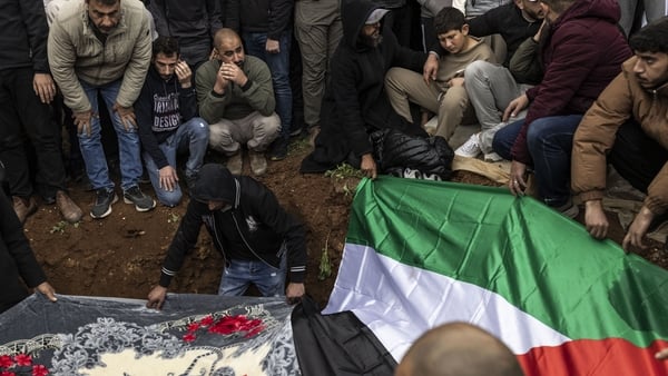 Mourners lower a body into a grave during a funeral for four members of a family in Tamoun, West Bank