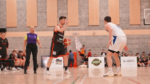 Ballincollig basketball player (left) on the ball, facing up against an opponent from Belfast Star.