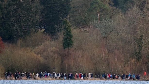 Large crowd of people standing on the shore of Lough Ennell