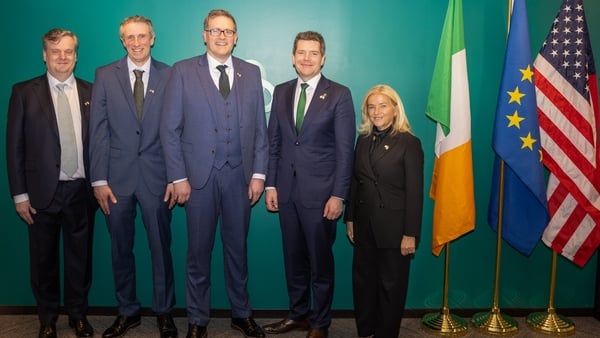 Group of business people pictured beside an Irish, European Union and US flags