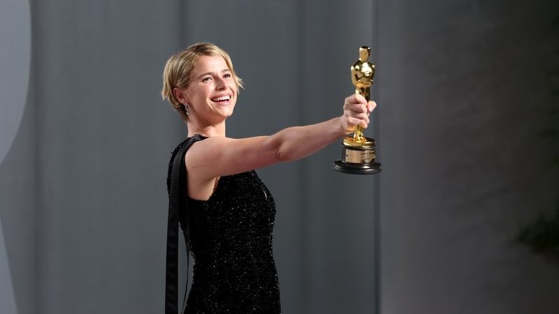 Jessie Buckley holds up her Oscar