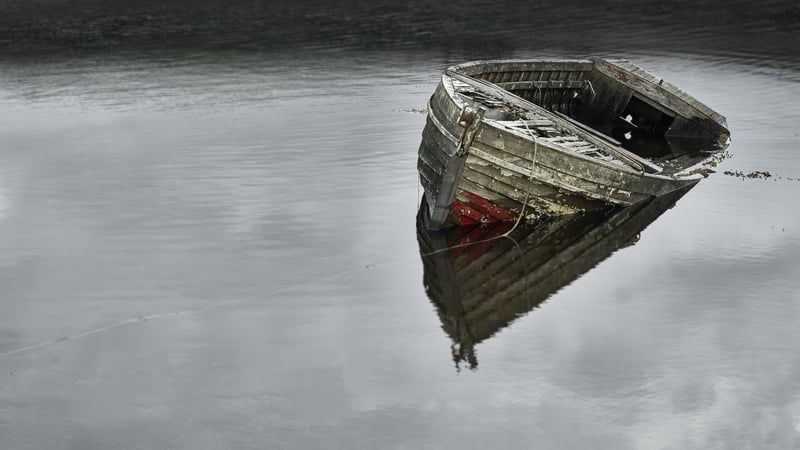 An abandoned dilapidated boat in a lake