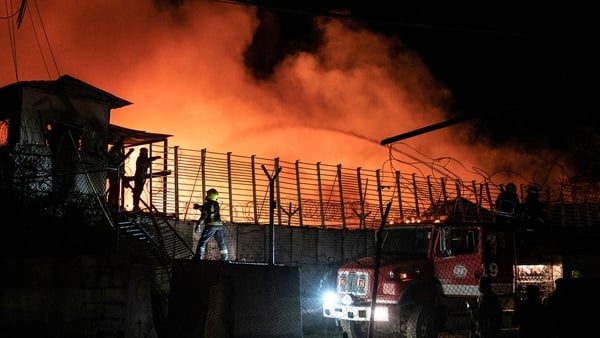 Afghan firefighters and Taliban security personnel work to extinguish a fire at the Secondary Rehabilitation Services Centre in Kabul