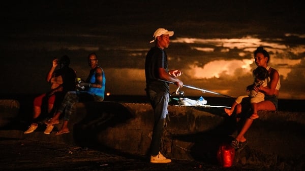 A man fishes accompanied by his family during a blackout in Havana