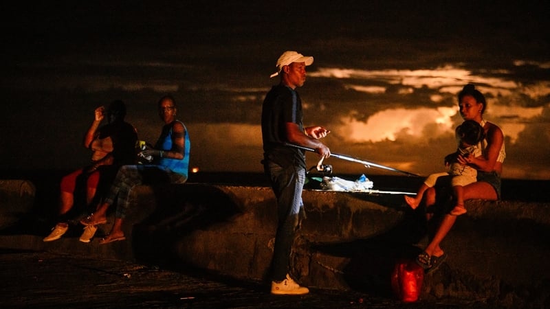 A man fishes accompanied by his family during a blackout in Havana