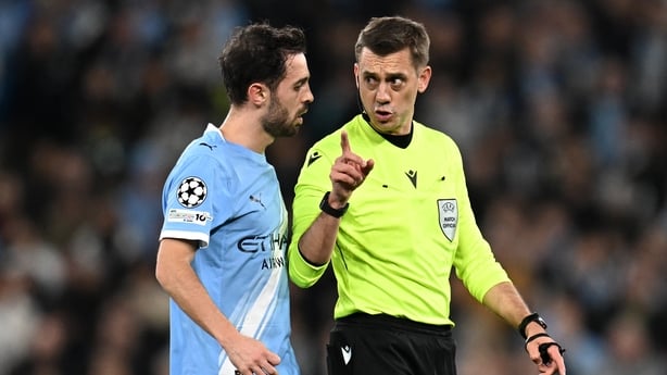 French referee Clément Turpin talks to Manchester City's Portuguese midfielder #20 Bernardo Silva during the UEFA Champions League, round of 16 second leg football match between Manchester City and Real Madrid at the Etihad Stadium in Manchester, north west England, on March 17, 2026.