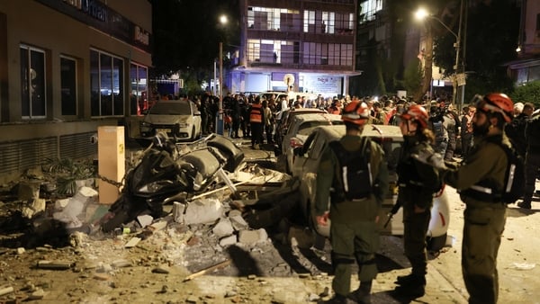 Police and first responders work at a scene where an apartment was damaged by a missile strike, in the outskirts of Tel Aviv, Israel