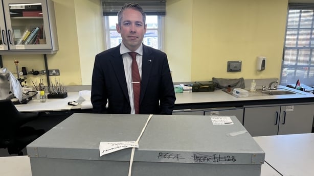 Det Sgt Paul Sweeney standing alongside a box