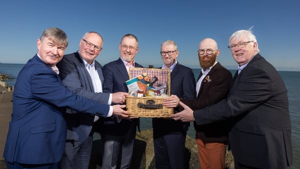 Image of a group of business men holding a basket of Irish food products