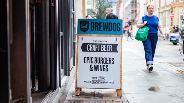 London, UK - 21 September, 2023: sign outside a Brewdog pub on a city street in central London. The sign is advertising Brewdog's wares, such as craft beer, burgers and wings. The sign also mentions that Brewdog is a carbon negative company. Focus on the