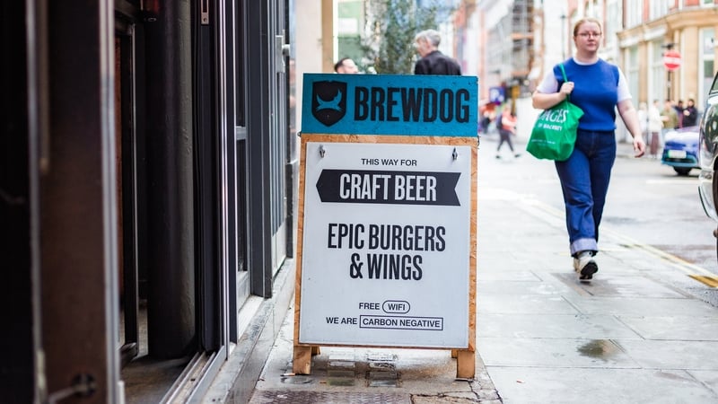 London, UK - 21 September, 2023: sign outside a Brewdog pub on a city street in central London. The sign is advertising Brewdog's wares, such as craft beer, burgers and wings. The sign also mentions that Brewdog is a carbon negative company. Focus on the