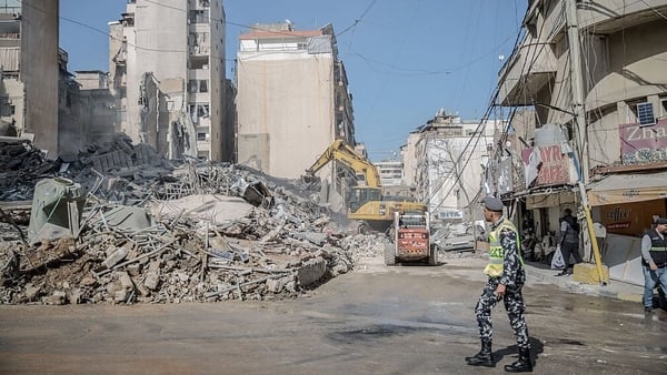 A policeman walks past the remains of a building in Bachoura, which was hit by an Israeli airstrike