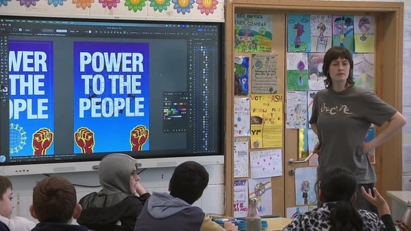 Woman gives a talk at the front of a classroom