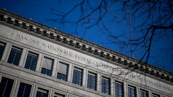 Image of the top of a grey building with a blue sky in the background