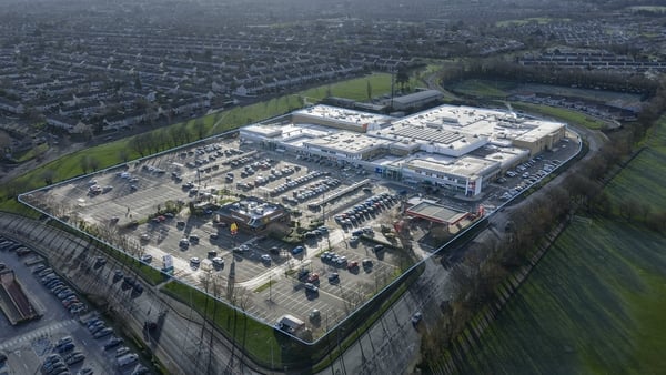 An aerial view of a shopping centre with a surface carpark surrounded by houses