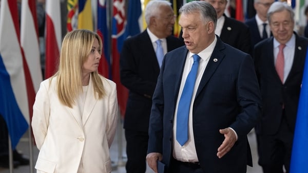 Hungary's Prime Minister Viktor Orban (R) speaks with Italy's Prime Minister Giorgia Meloni
