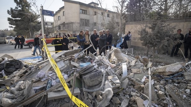 Iranian families gather behind the ruins of a building in Tehran, Iran, on March 18, 2026. The building was destroyed during a U.S.-Israeli military operation. The gathering takes place on the eve of the Iranian New Year. (Photo by Morteza Nikoubazl/NurPhoto via Getty Images)