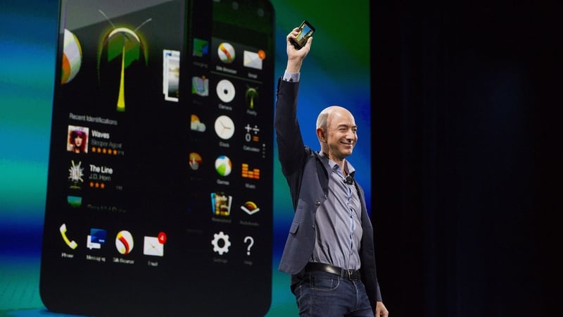 Image of a business man holding a smartphone with images of phone screens behind him