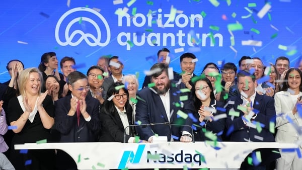 Image of a group cheering and clapping with the Horizon Quantum signage in the background on a stage with Nasdaq sigage