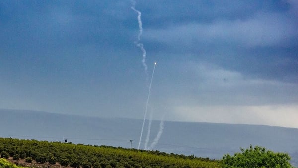 Iron Dome interceptors go up behind a group of Israeli soldiers along the border with Lebanon,