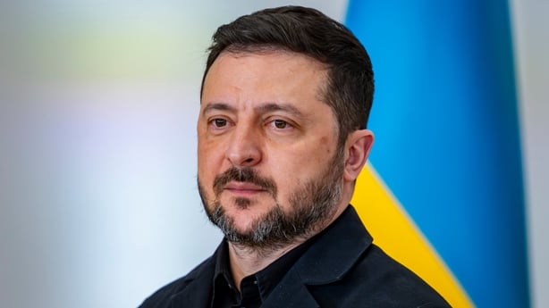 Volodymyr Zelensky is seen during his official visit to Spain with a Ukrainian flag - blue and yellow - behind him