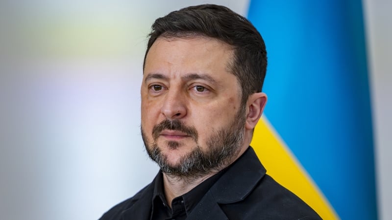 Volodymyr Zelensky is seen during his official visit to Spain with a Ukrainian flag - blue and yellow - behind him