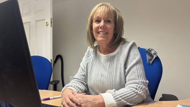 Susan Gaughran sits at a desk.