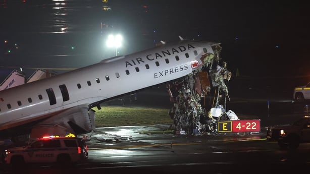 An Air Canada Express CRJ-900 sits on the runway after colliding with a Port Authority fire truck at LaGuardia Airport 