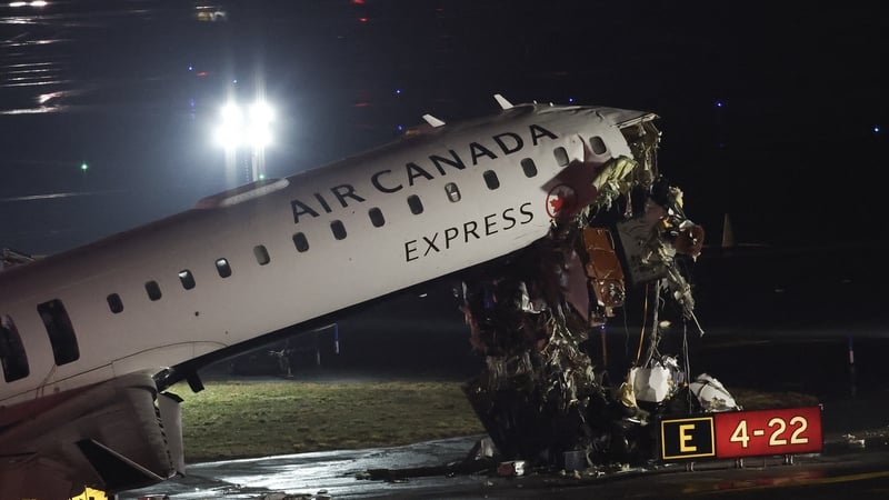 An Air Canada Express CRJ-900 sits on the runway after colliding with a Port Authority fire truck at LaGuardia Airport