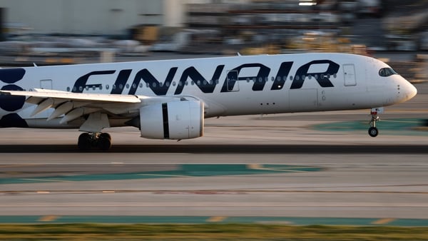 A plane lands at an airport with the Finnair sigange on it