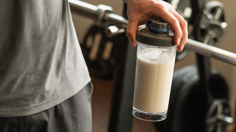A man holding a protein shaker at a gym