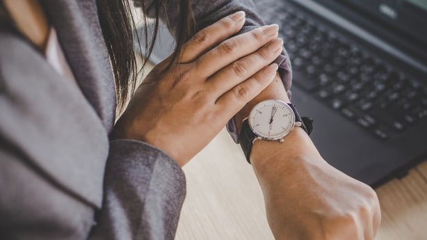 businesswoman checking the time on watch at her office waiting for someone coming late