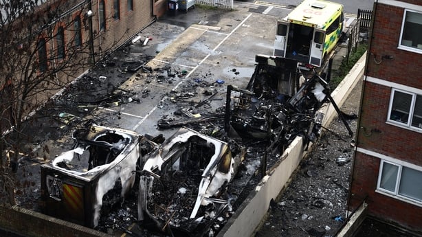 Burnt out ambulances are pictured in a parking area along a street in the Golders Green neighbourhood of north London