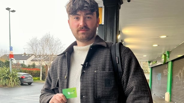A man holds a Leap card as he poses for a photograph
