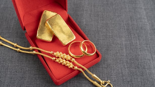 Gold necklaces in a red velvet box on a black textile