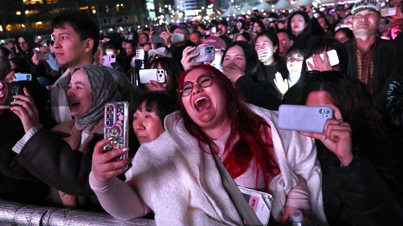 BTS fans react as they watch the comeback concert of K-pop boy group BTS on a screen at the venue in Seoul on March 21, 2026. South Korean megastars BTS reunited on 21 March for their first show in nearly four years. (Photo by Jung Yeon-je / AFP)