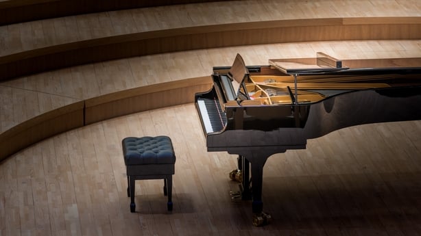 Tiered seating, evoking solitude, anticipation, and refined musical performance in an intimate concert hall.