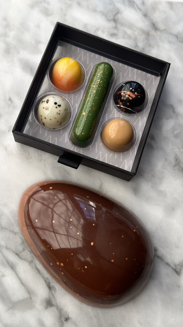 A box of colourful chocolates and a chocolate Easter egg