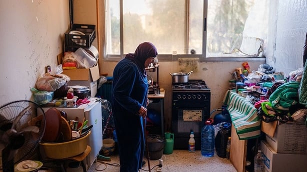 An elderly displaced woman stands in her room at a school being used as a shelter in Tyre, Lebanon