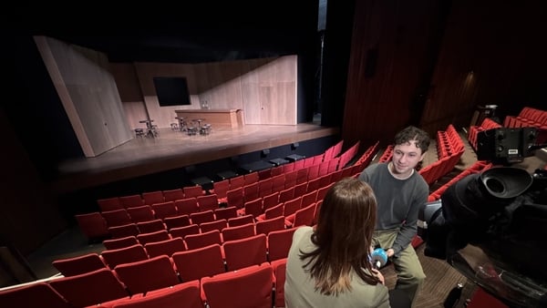 Actor being interviewed by TV reporter high up in the seats at the Abbey