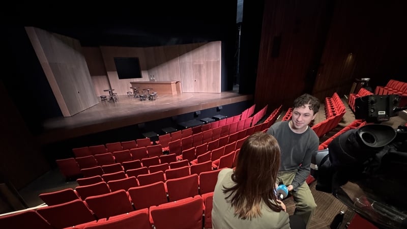 Actor being interviewed by TV reporter high up in the seats at the Abbey