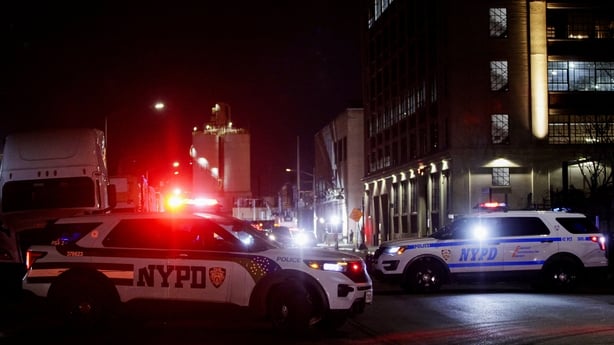 Police cars with NYPD logs are seen outside a building at night