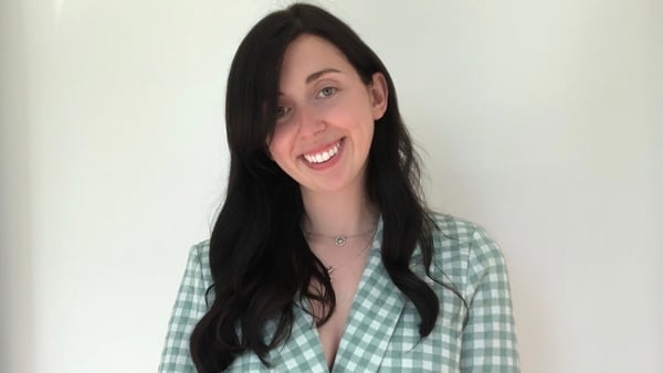 Irish teacher Cass Ní Chionnaith poses in front of a blank backdrop.