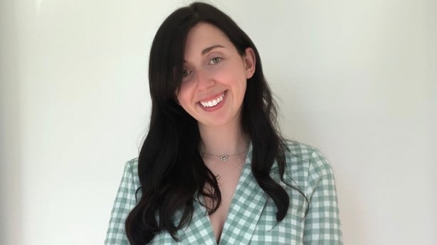 Irish teacher Cass Ní Chionnaith poses in front of a blank backdrop.