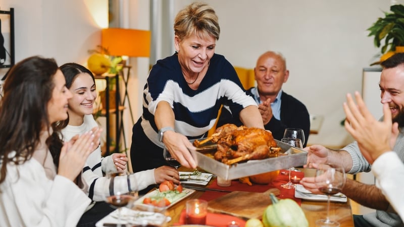 Family Looking Happy While Mother is Carrying Homemade Roasted Turkey (Getty Images)