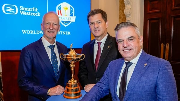 Image of three men standing around a golf trophy with Smurfit Westrock signage behind them