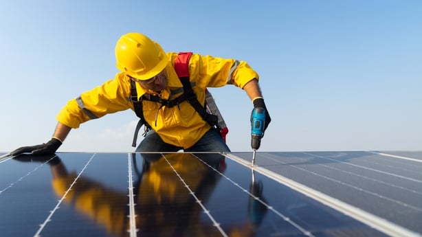 Solar panel technician with drill installing solar panels on roof,electrician panel sun sustainable resources renewable energy source alternative innovation.