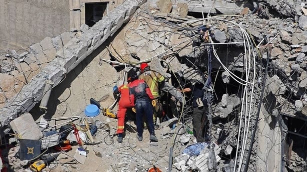Rescue workers search for bodies in the rubble of a residential building following a hit in an airstrike in Tehran