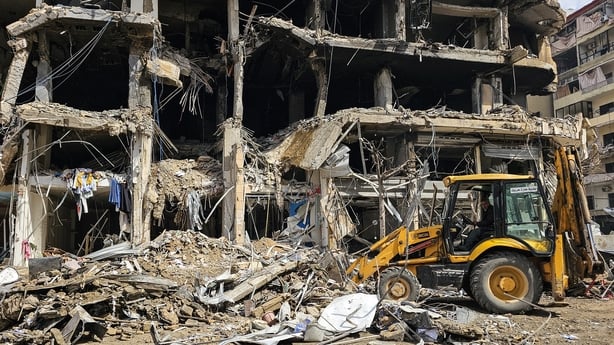 A bulldozer clears rubble